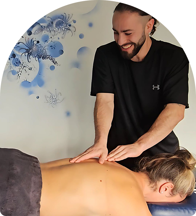 Massage therapist providing remedial massage to a client in a serene setting, emphasizing pain relief and relaxation, with a calming blue wall design in the background.