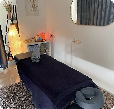 Wellness on Shore treatment room with massage table, calming decor, and warm lighting, showcasing a serene environment for wellness services.