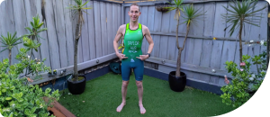 Man in athletic gear showcasing a personal training outfit in a garden setting, emphasizing fitness and wellness.