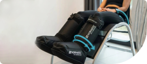 Normatec compression boots on a person’s legs, illustrating advanced muscle recovery and circulation benefits in a wellness setting.