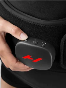 Person holding Hyperice Venom 2 device for back pain relief, showcasing wellness technology in fitness and recovery context.