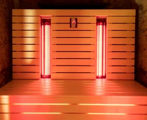 Infrared sauna interior with glowing red lights and wooden slats, emphasizing wellness and detoxification benefits.