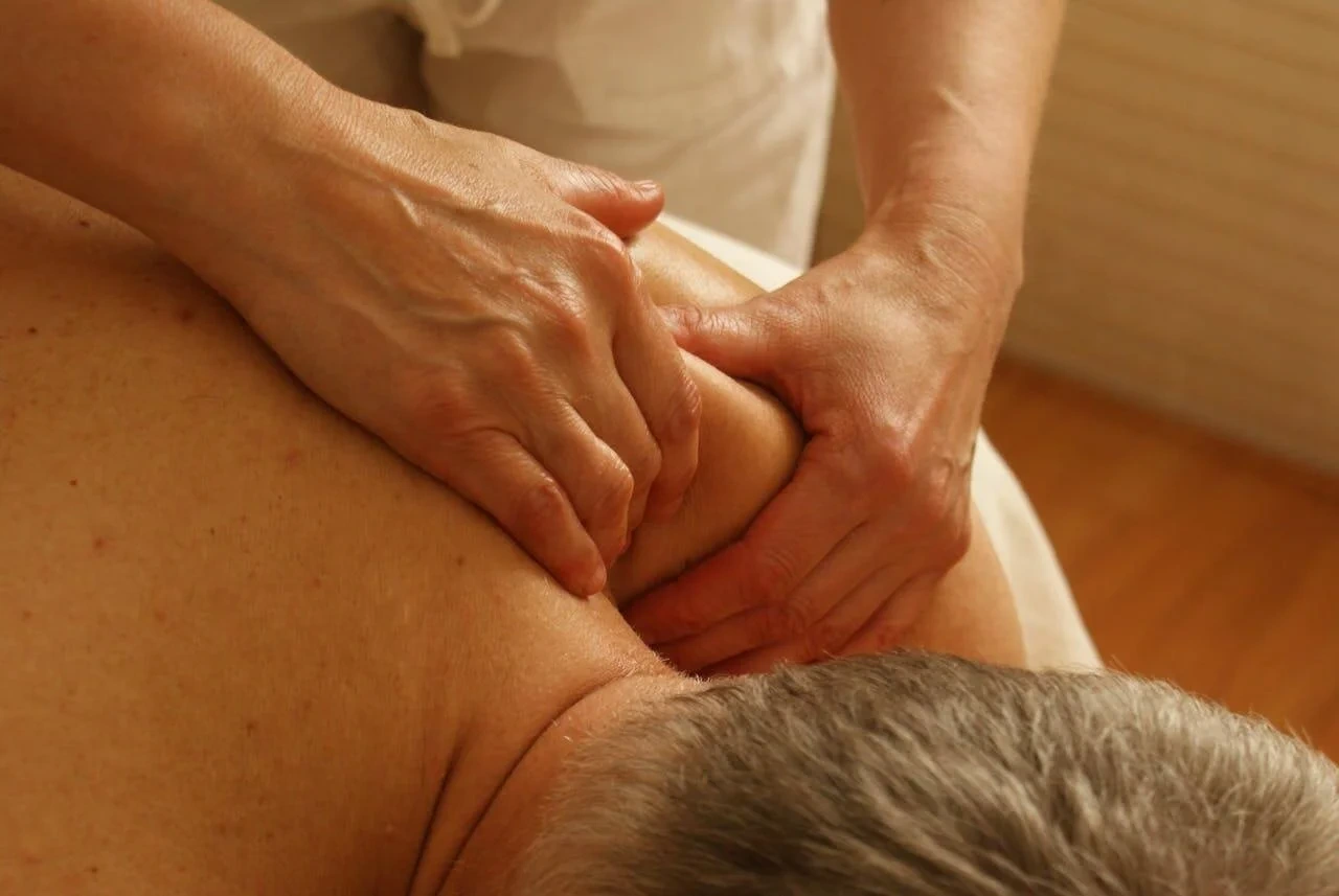 Therapist performing remedial massage on a client's upper back, focusing on soft-tissue techniques for pain relief and muscle recovery at Wellness Onshore.