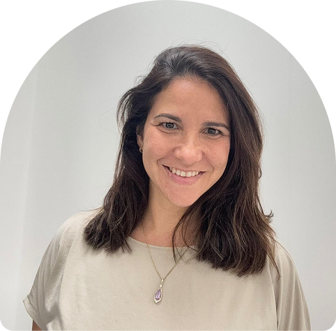Chilean physiotherapist Paulina smiling, with shoulder-length dark hair and a casual light-coloured top, representing Wellness on Shore's focus on rehabilitation and wellness services.